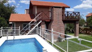 a house with a swimming pool and a balcony at Bosysol en las sierras in Merlo