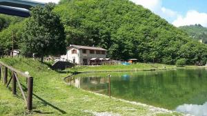 a house on a hill next to a body of water at Taverna del Dolmen in Millesimo