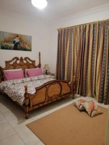 a bedroom with a wooden bed and curtains at Arabian Suites in Amman