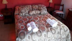a bed with two pairs of white slippers on it at Bosysol en las sierras in Merlo +5 photos