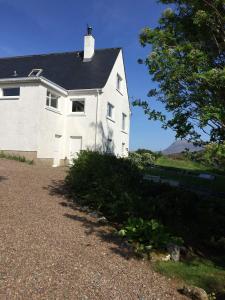 a white house sitting on top of a hill at Tor Druim in Drumbeg