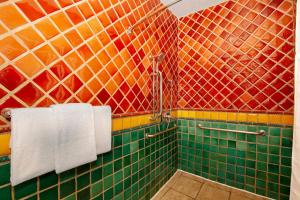 a bathroom with colorful tiled walls and white towels at El Cordova in San Diego