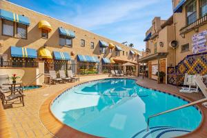 una piscina en un hotel con mesas y sillas en El Cordova en San Diego