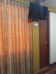 a room with a curtain and a lamp and a door at El Marquez in Tacna