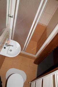 a bathroom with a sink and a toilet in a room at Penzión MAX in Podhájska