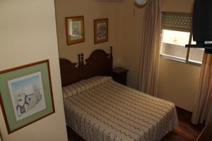a bedroom with a bed and a window at Hostal Andalucia in Almuñécar