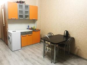 スルグトにあるTyumenskiy trakt 6/1のキッチン(テーブル付)、小さなキッチン(オレンジ色のキャビネット付)