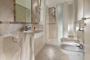 un bagno con due lavandini e un water di Hotel Ada a Rimini