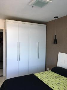 um quarto com armários brancos e uma cama em Apartamento linda vista, 200 metros da praia de camboinhas em Niterói mais 13 fotografias