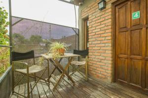 a patio with a table and chairs on a balcony at La Casita de Salta in Salta