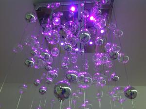a chandelier with purple lights hanging from a ceiling at Hotel Lux in Caorle