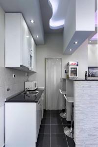 cocina con armarios blancos y suelo negro en Apartment Royal, en Belgrado