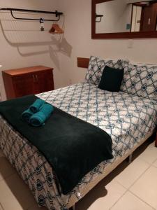a bed with two pillows on it in a bedroom at Pippo Suites Guarujá in Guarujá