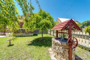 a fountain in a yard with a tree and a fence at Marulan Stayz in Marulan