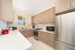 a kitchen with wooden cabinets and a stainless steel refrigerator at Marulan Stayz in Marulan
