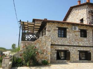 an old stone house with a wooden roof at Psakoudia Villas in Psakoudia