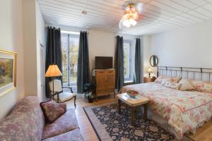 a bedroom with a bed and a couch at Manoir Sur le Cap in Quebec City