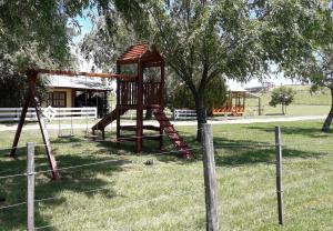 un parque infantil con un árbol y un columpio en Posada del Campo en San José