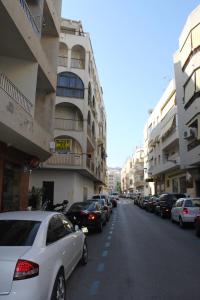 uma fila de carros estacionados numa rua ao lado de edifícios em Hostal Andalucia em Almuñécar