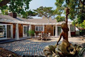 a statue of a mermaid in front of a house at Lighthouse Lodge & Cottages in Pacific Grove