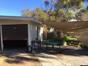 un cobertizo con una mesa de picnic y toldo sobre él en The Kite Beach House, en Guilderton