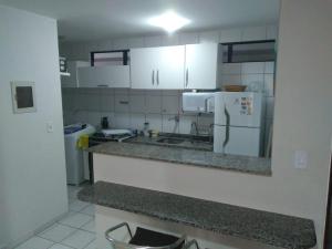 a kitchen with white cabinets and a counter top at Apartamento na orla de Maceió in Maceió
