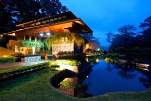 un edificio con un laghetto di fronte ad esso di notte di El Tucano Resort & Thermal Spa a Quesada