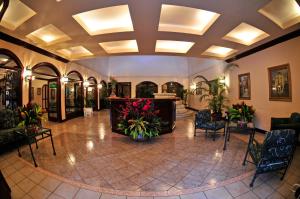 a lobby with chairs and flowers in a building at El Tucano Resort & Thermal Spa in Quesada
