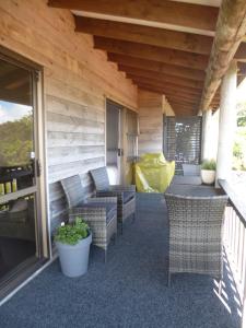 a porch with wicker chairs and tables on a house at Opua Boutique Seaview Motel in Opua