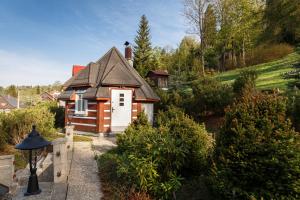 a small house with a white door in a garden at Roubenka Anna in Dolní Polubný