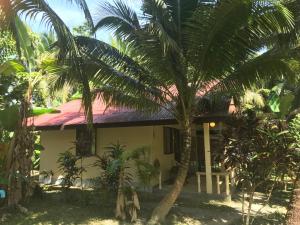 a house with palm trees in front of it at Lake View Bungalows in Khao Lak