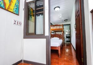Zimmer mit einem Bett und einer Tür zu einem Schlafzimmer in der Unterkunft Hotel Flor Blanca in Manuel Antonio