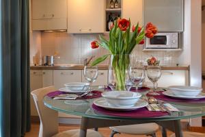a dining room table with a vase of flowers on it at Elite Hotel & Spa in Mestre