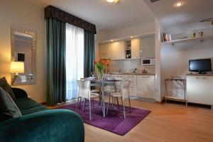 a living room with a table and chairs and a kitchen at Elite Hotel & Spa in Mestre