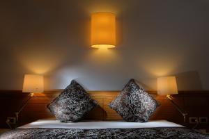 a bedroom with two pillows on a bed with two lights at Elite Hotel & Spa in Mestre