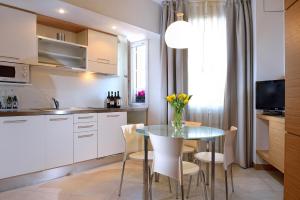 a kitchen with a glass table and white cabinets at Elite Hotel & Spa in Mestre