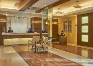 a lobby with people working at a reception desk at Astoria Hotel in Mumbai