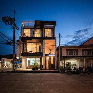 a tall building with a balcony on a street at The Hotel Zealonta in Ko Lanta