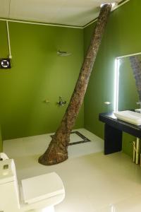 a bathroom with a tree growing out of the wall at Abidal Resort in Patnem