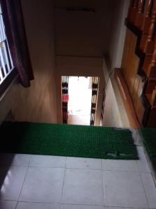 a room with a green floor and a window at Vamoose Buddha Hotel Tawang in Tawang
