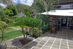 a patio with an umbrella and a table and chairs at Lariad BnB in Flic-en-Flac