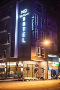 a building with a sign on the side of it at night at MD Boutique Hotel in Kampar