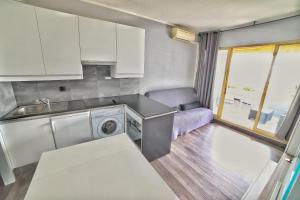 uma cozinha com um lavatório e uma máquina de lavar roupa em Apartment hotel Luxe climatisé vue mer magnifique étage 11 em Villeneuve-Loubet