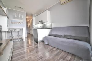 ein Wohnzimmer mit einem Bett und eine Küche in der Unterkunft Apartment hotel Luxe climatisé vue mer magnifique étage 11 in Villeneuve-Loubet