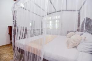 Ένα ή περισσότερα κρεβάτια σε δωμάτιο στο Simon's Lodge Hikkaduwa
