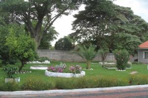 a garden with flowers and trees in a yard at Amazing Guest House in Harare