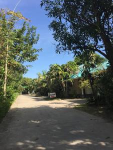 eine Straße vor einem Gebäude mit Bäumen in der Unterkunft First Garden Home Resort in Si Sa Ket