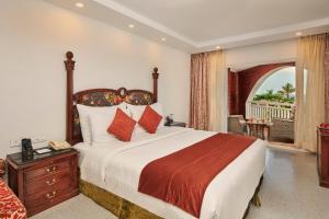 a bedroom with a large bed with a wooden headboard at Mayfair Heritage in Puri