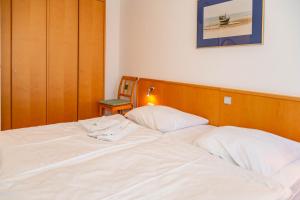 DewichowにあるApartment Naturgenuss mit Terrasseの白いベッド1台(木製ヘッドボード付)が備わるベッドルーム1室が備わります。