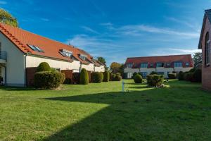 una fila di case in un giardino con cespugli di Kranich - Ferienwohnung mit Terrasse a Dewichow